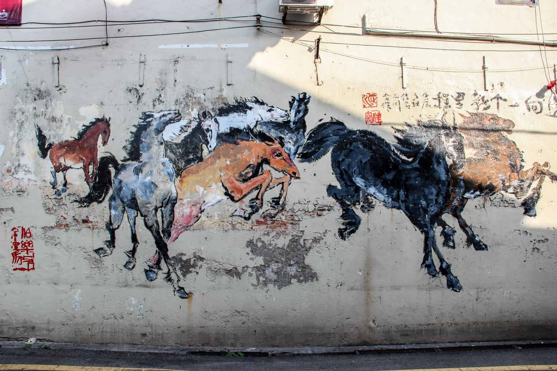 Aart mural of wild horses on a wall in Melaka's Chinatown district, Malaysia