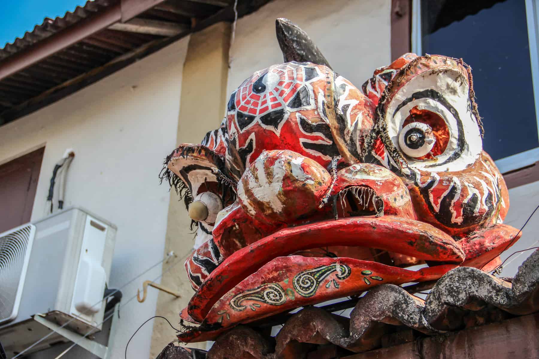 A large gold and red painted dragon head on a building in Chinatown, Melaka, Malaysia