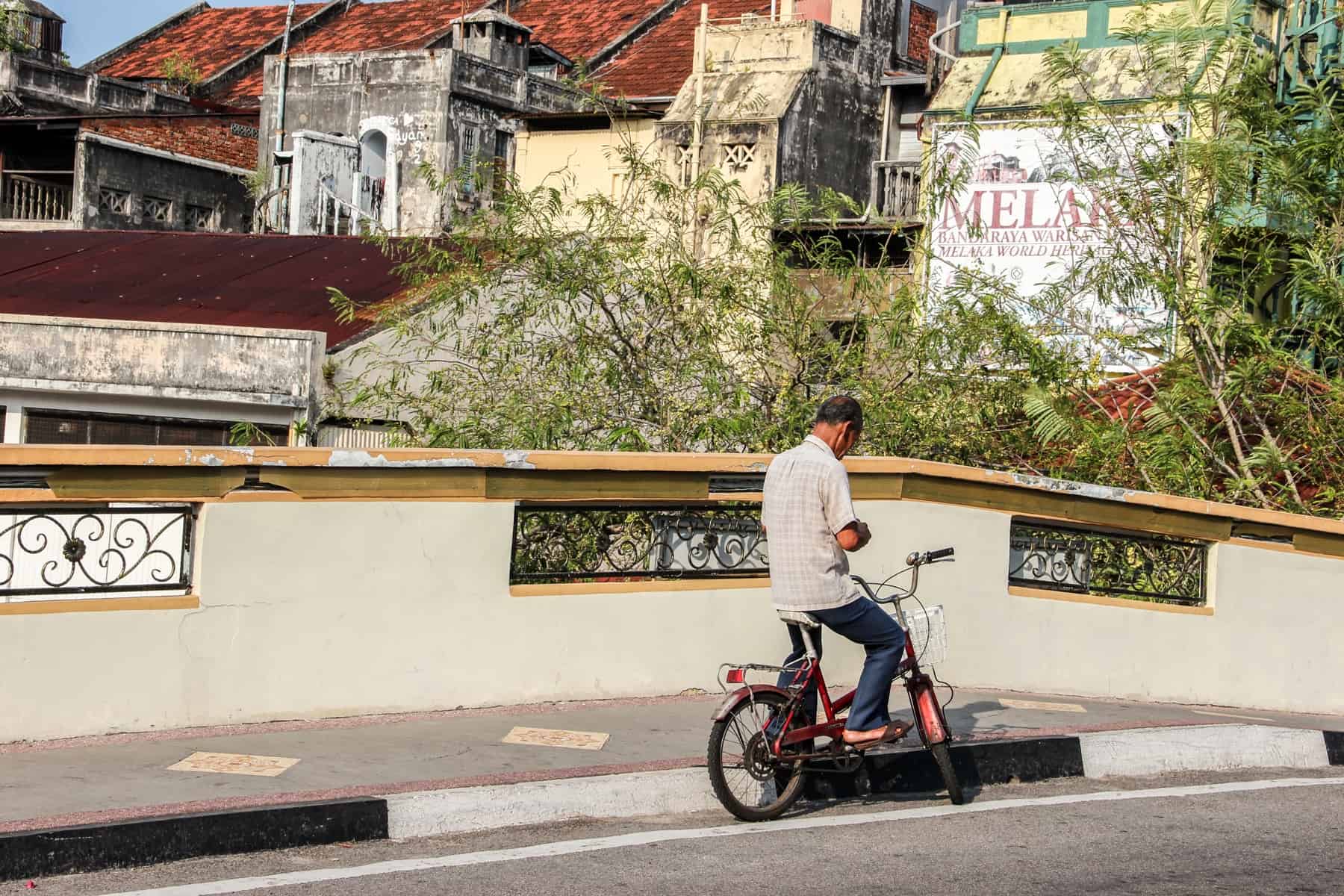 A local riding his bike on a road bridge in Melaka, Malaysia