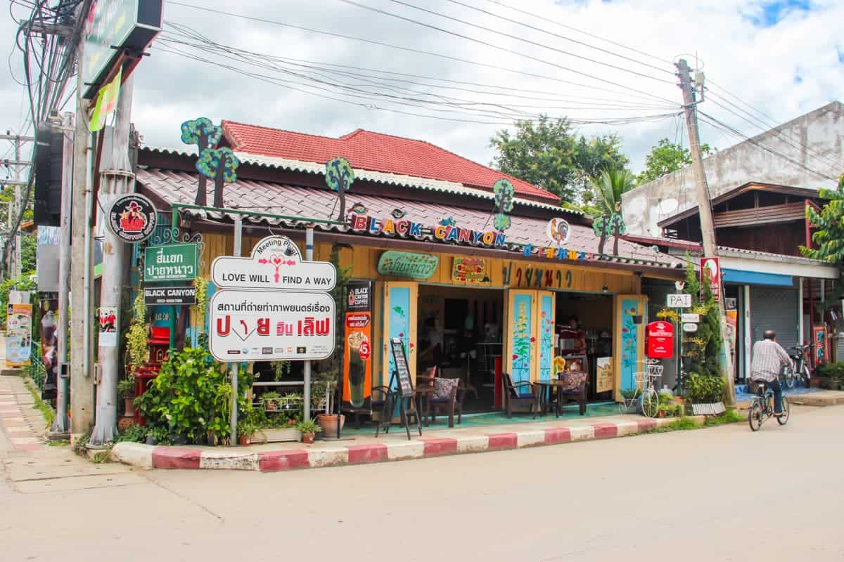 Un hombre pasa junto a una colorida tienda en la tranquila ciudad de Pai, en el norte de Tailandia