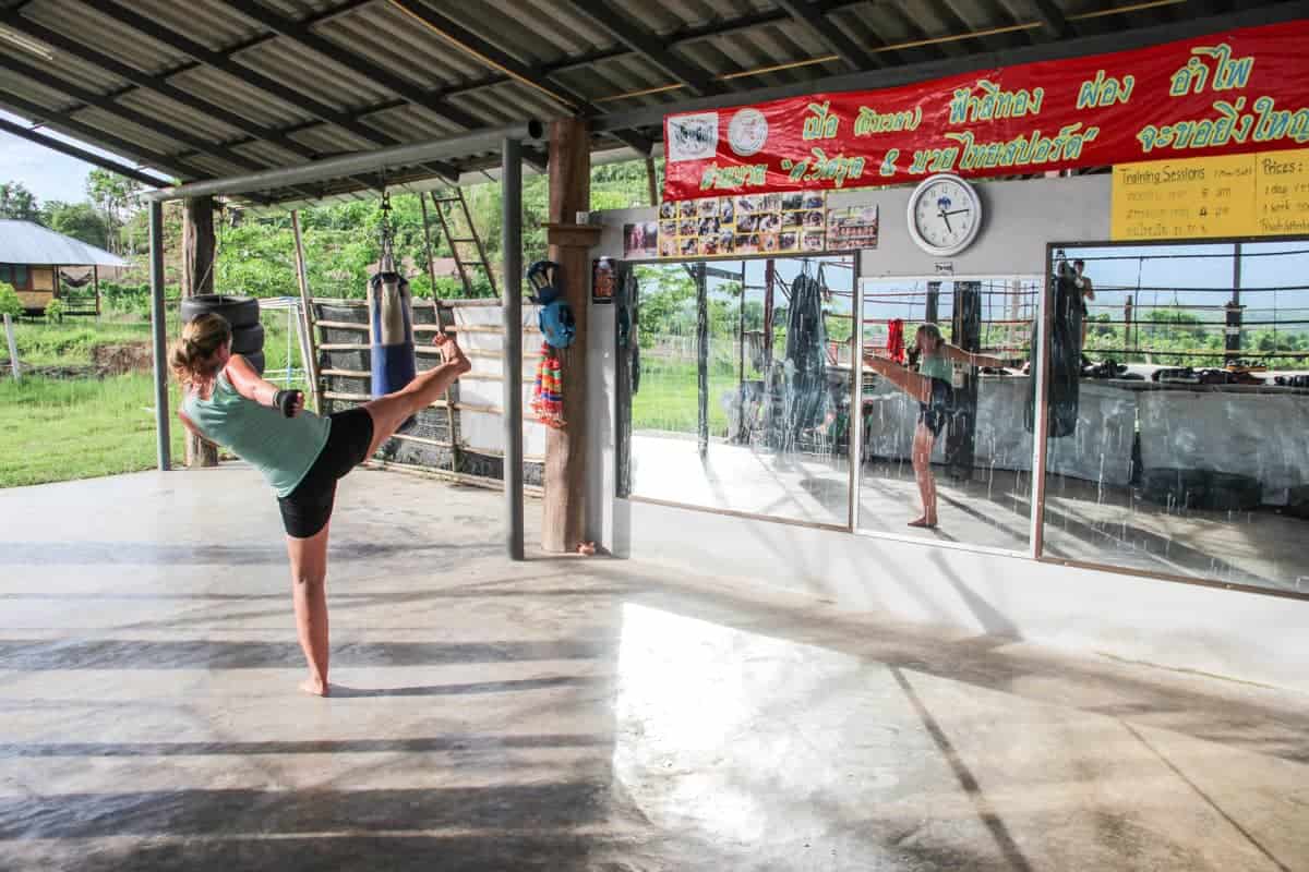Mujer frente al espejo en un gimnasio de boxeo tailandÃ©s practicando Muay Thai