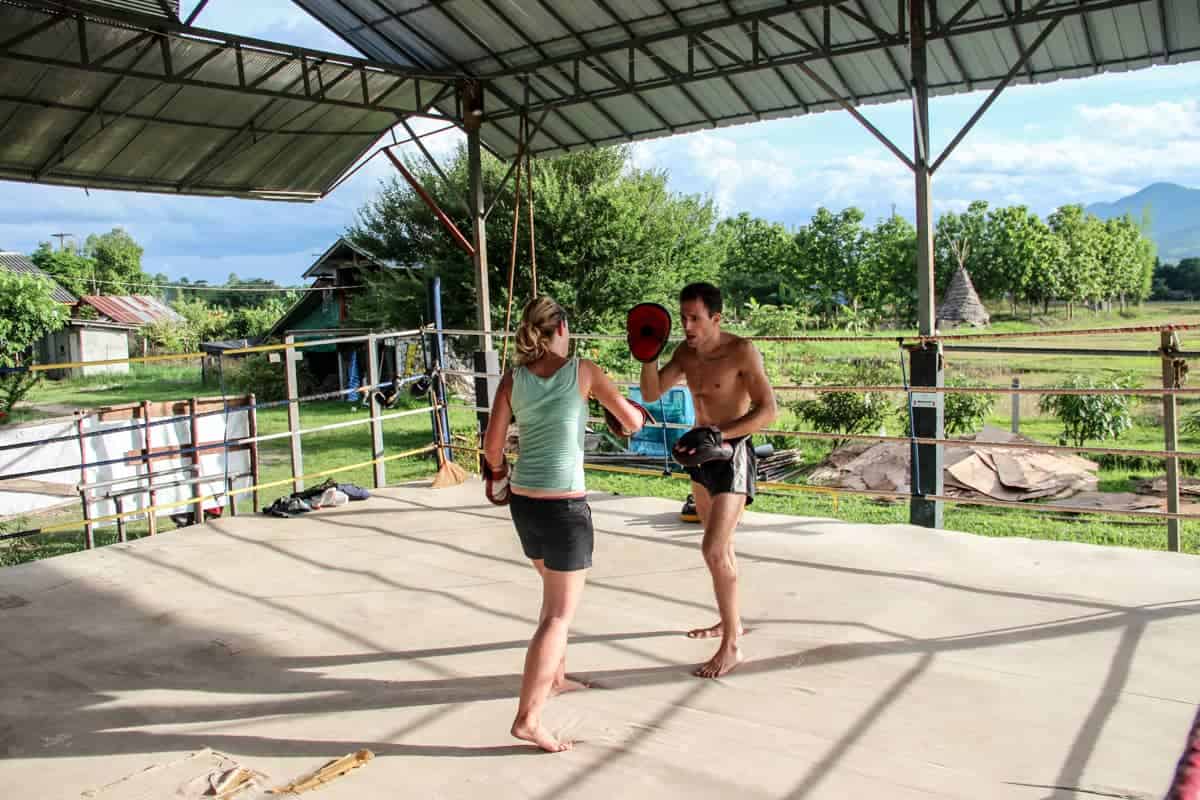 A woman spars with an instructor during a session of Muay Thai training in Thailand