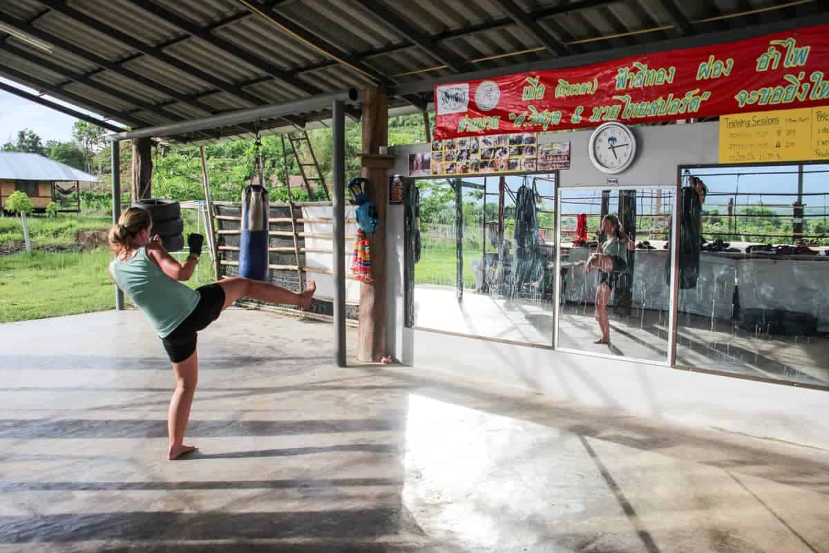 Woman in kick stance during a session of Muay Thai training in Pai, Thailand