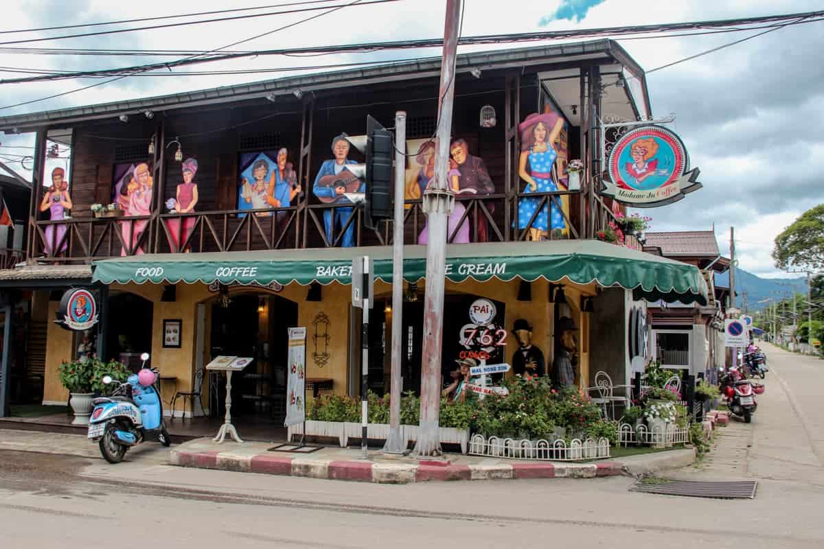 A restaurant in Pai town adorned with artistic murals of people 