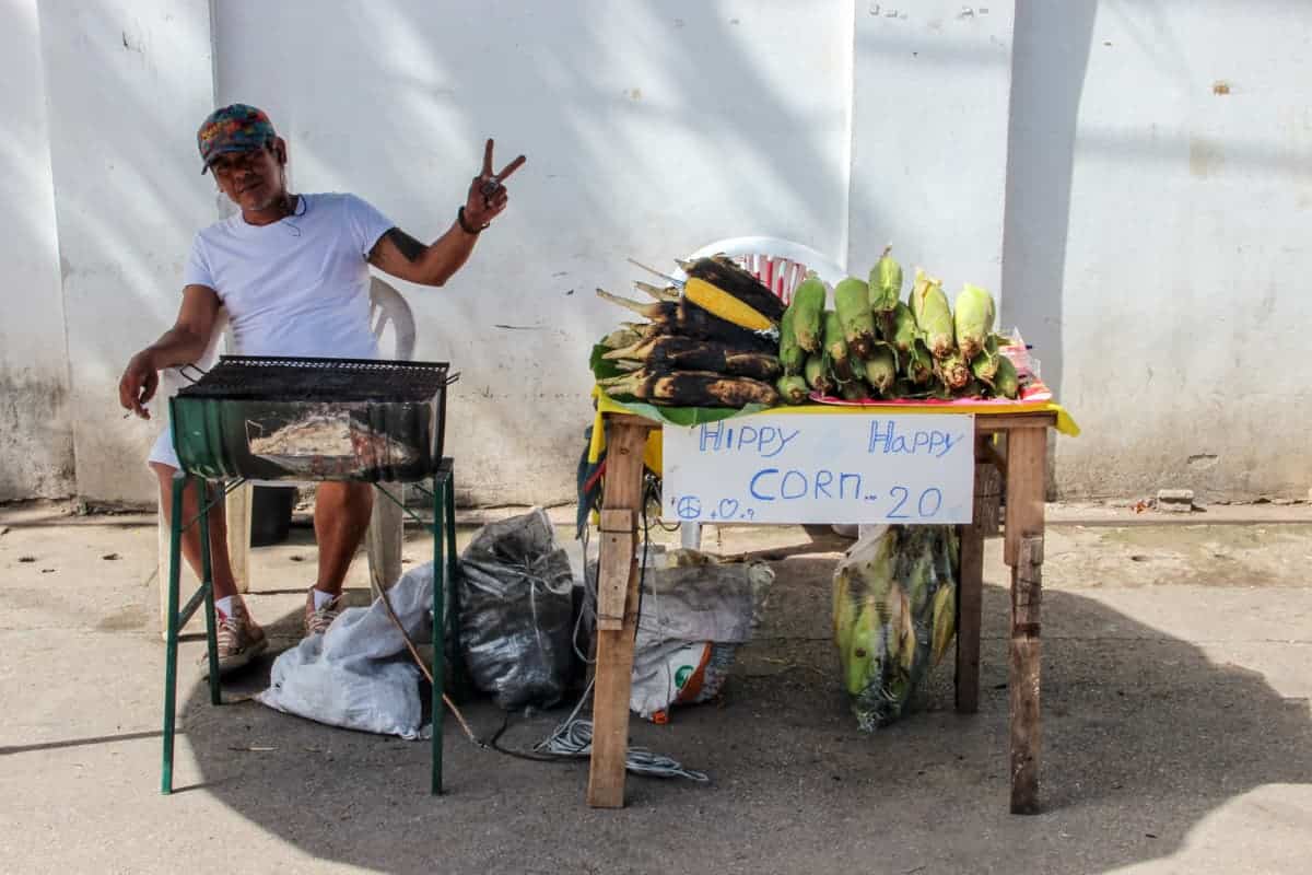 A man in Pai, Northern Thailand sells fruit from his small street-side table