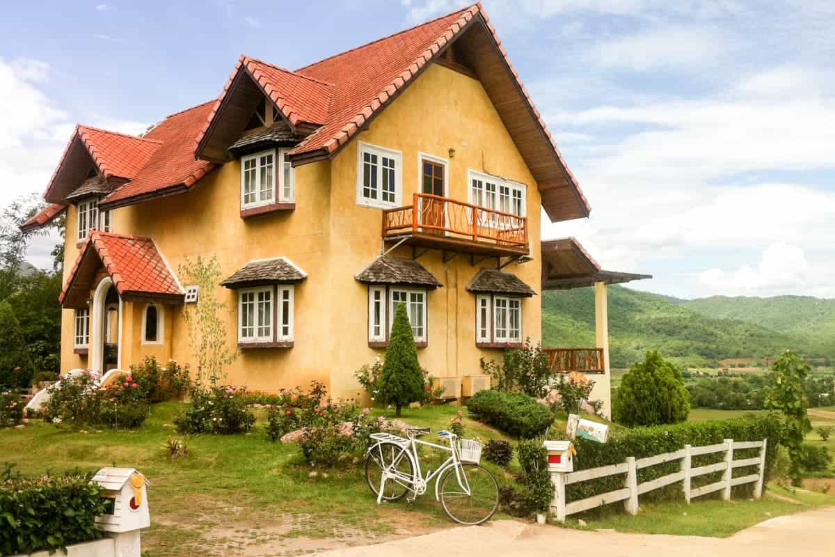 A storybook style bright yellow house on the top of the hillside in Pai, Northern Thailand