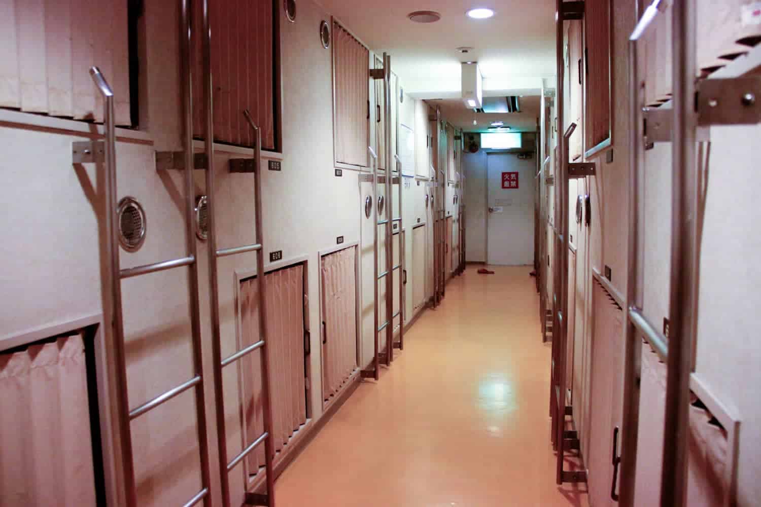 A typical corridor with box rooms either side with shutter curtains - a typical set up in a capsule hotel in Japan.