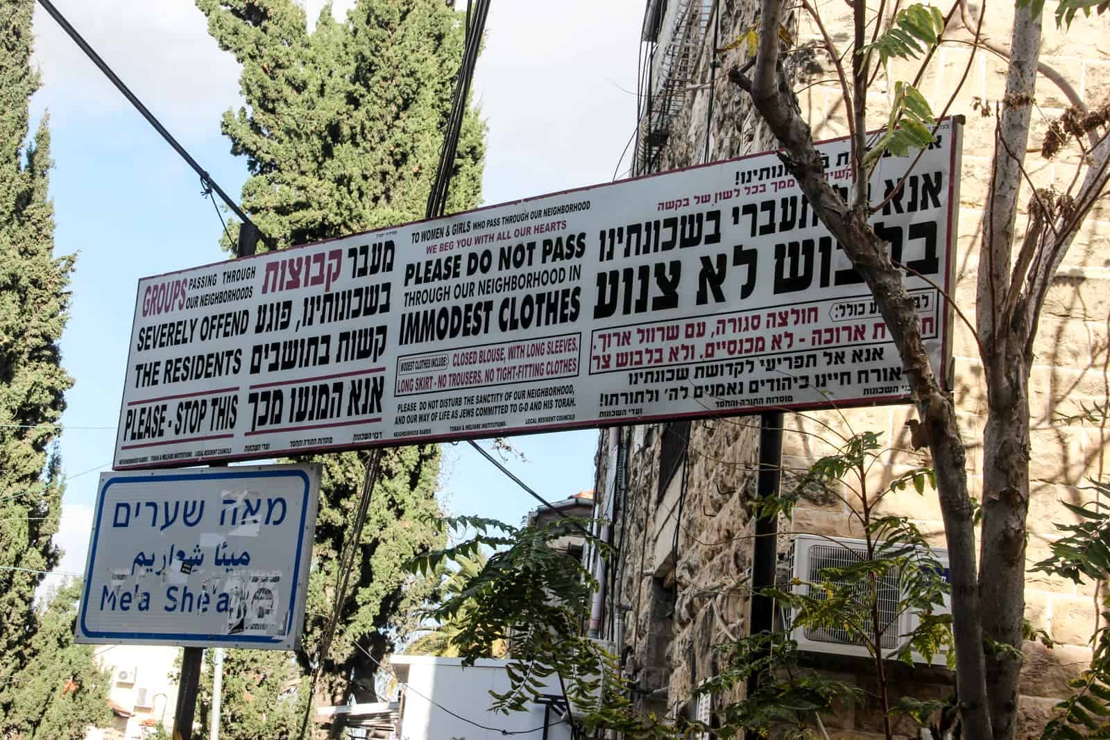 A sign in an Orthadox Jewish neighbourhood in Jerusalem stating "Please do not pass through our neighbourhood in Immodest Clothes" and other statements in Hebrew