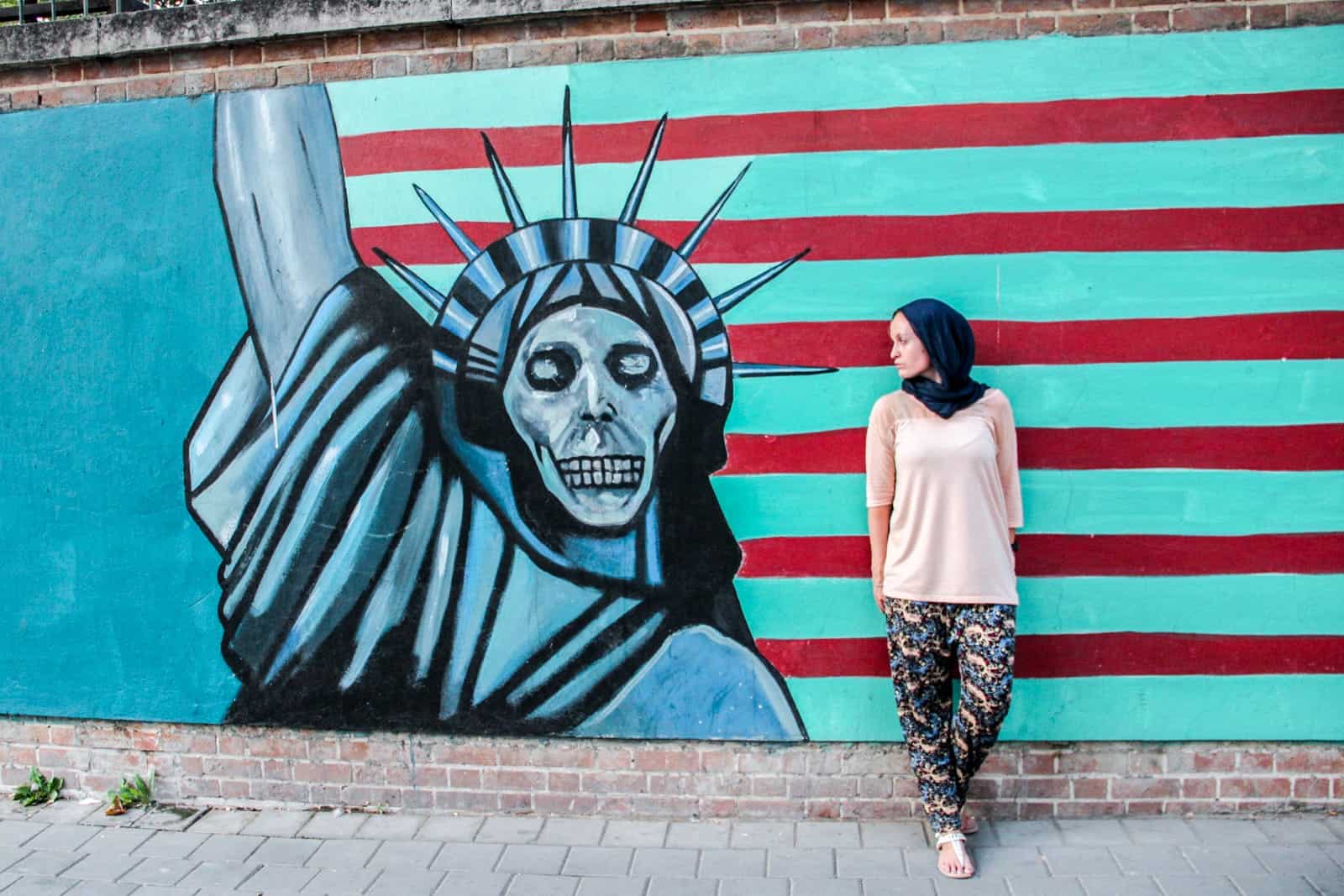 Traveller outside the US embassy in Iran with anti US graffitti