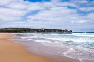Long, golden sand beaches, backed by low cliffs, and the wide ocean waves of the coastline of southern Australia.