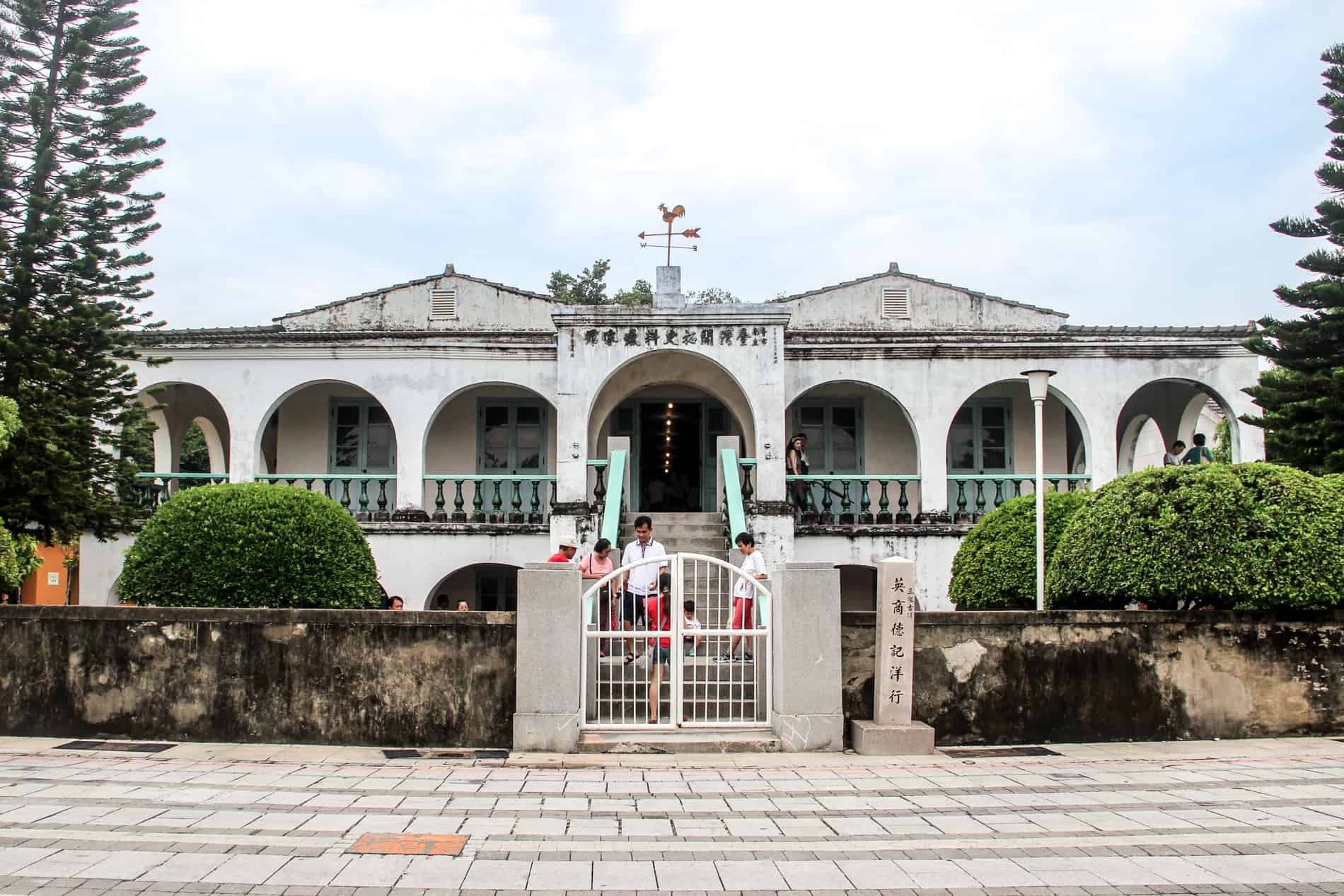 People at the staircase of an white arcaded colonial style building - the former Tait & Co Merchant House in Tainan. 