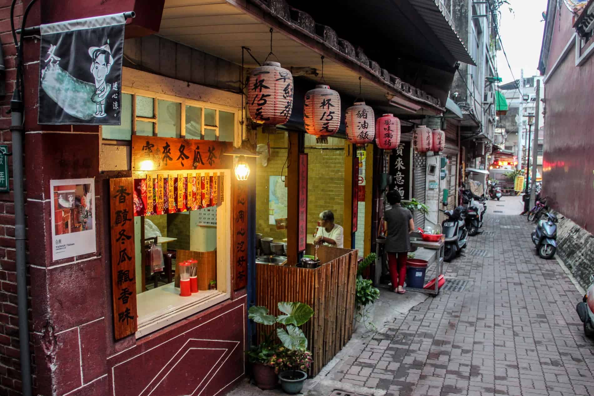 A restaurant with red lanterns on a narrow street in Tainan, Taiwan.