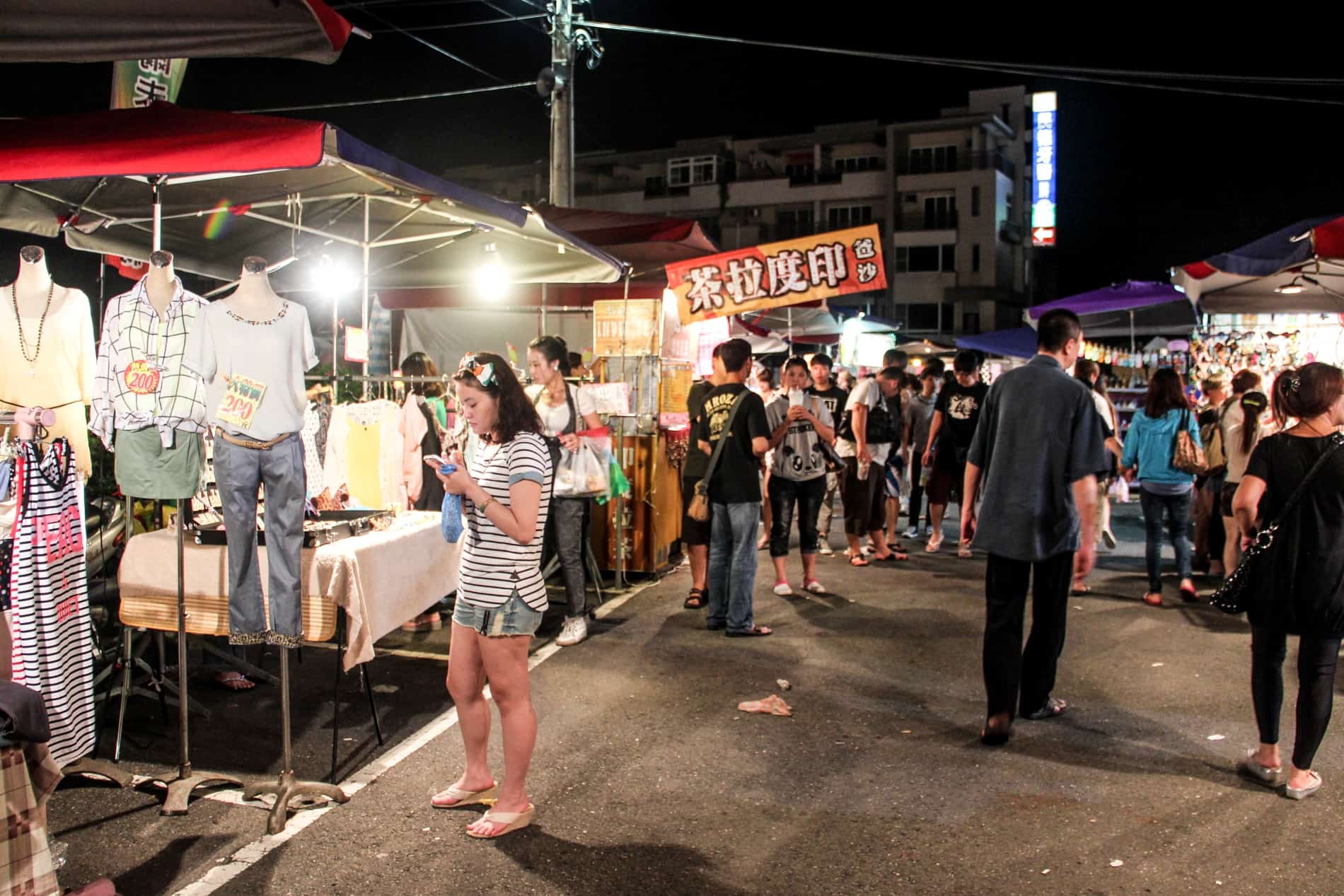 People browsing the clothing stalls at a Night Market - one of the best things to do in Tainan, Taiwan. 