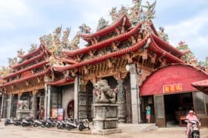 The etched stone columns and multi-coloured roof carvings of the Luermen Matsu Temple in Tainan.