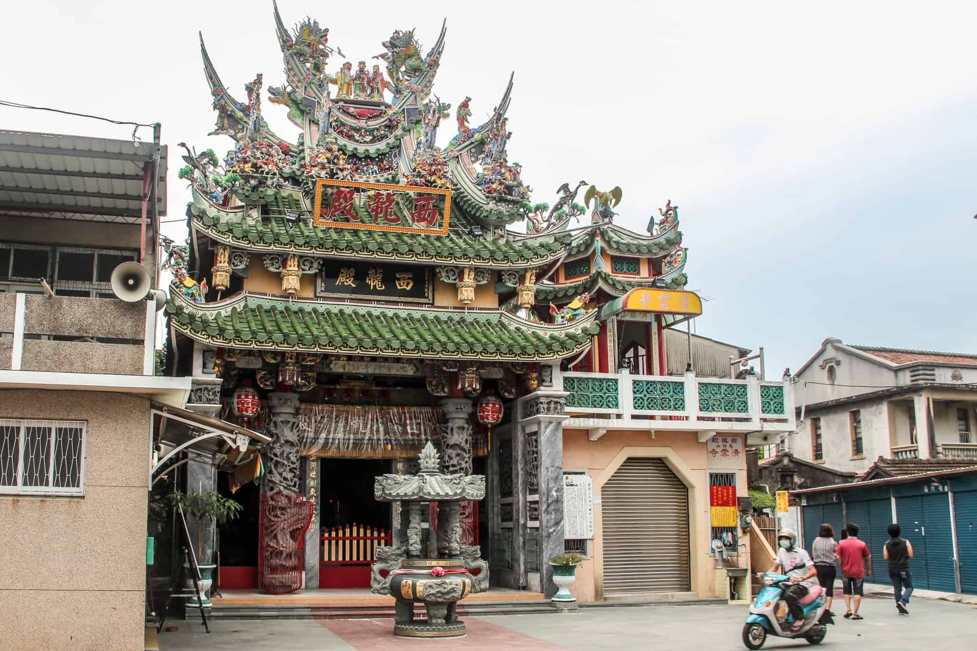 The silver stone, green roof tiles and carvings of the Xishe Xilong Temple in Tainan.