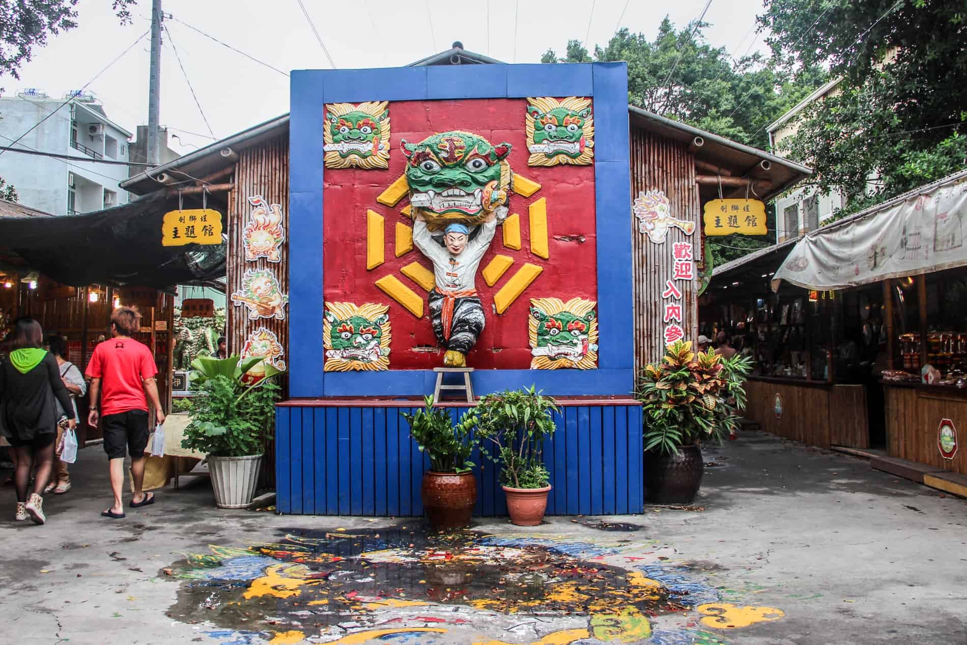 A colourful carving on a man holding onto a sword in a dragons mouth - one of Sword-Lion heads in Tainan. 