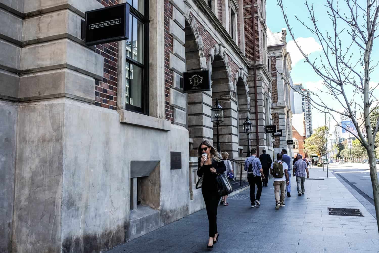 The exterior decor and arched windows of one of Perth's State Buildings now lined with signs for the boutique stores and eateries inside 