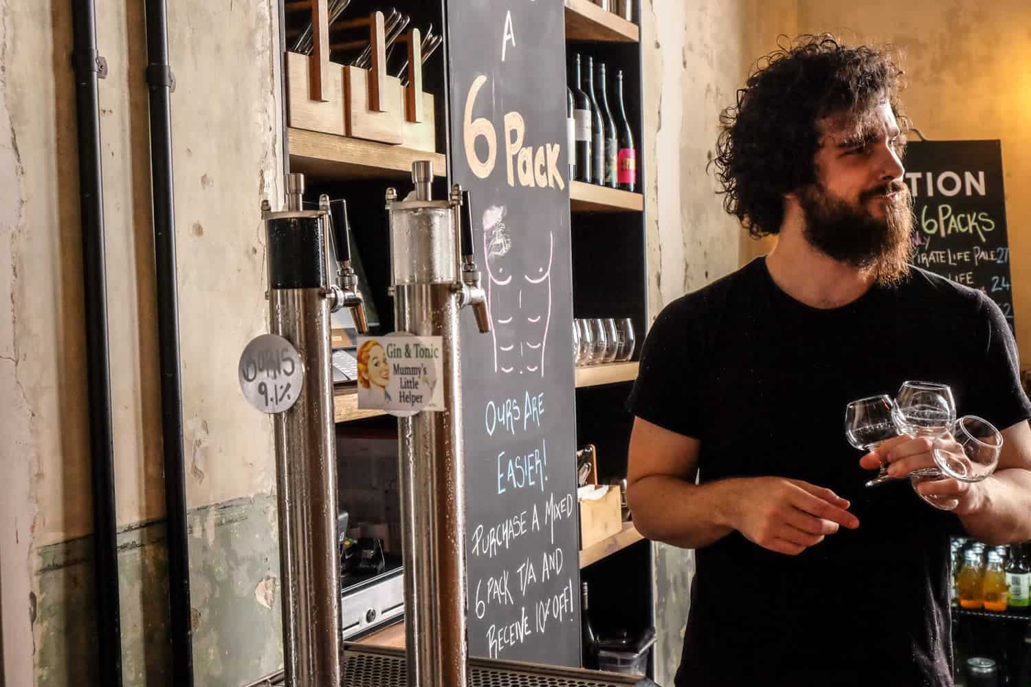 Un hombre muestra el grifo Gin and Tonic en la pequeña cervecería de Petition Kitchen en Perth