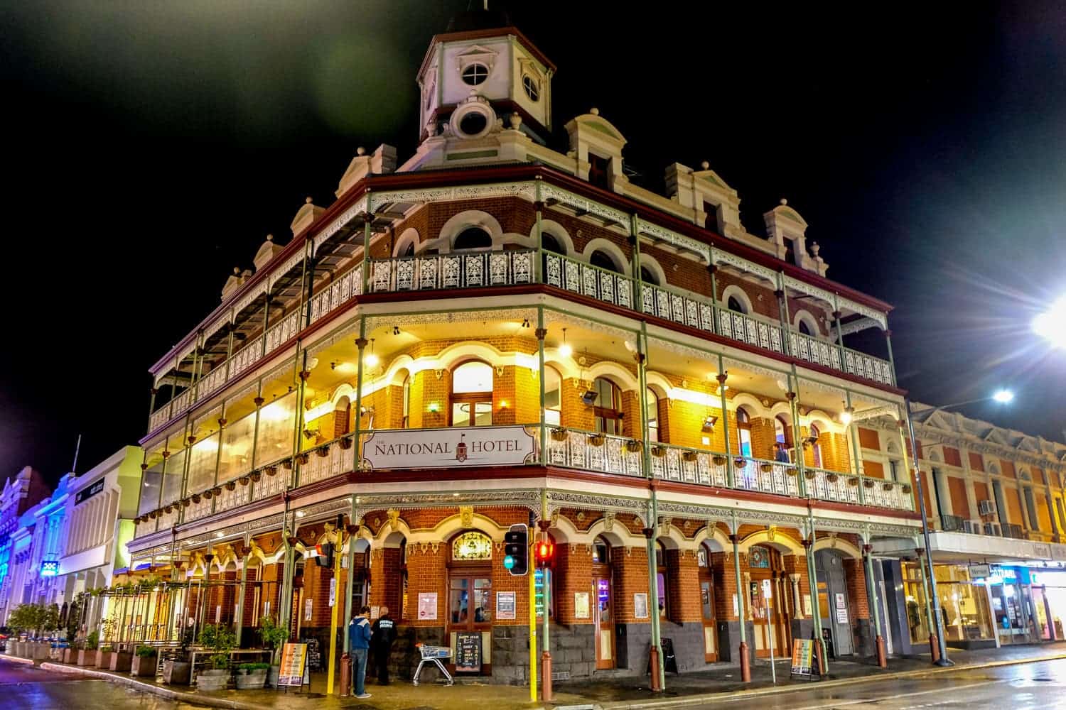 Los arcos de las ventanas de ladrillo rojo y los adornos blancos del hotel National en Perth por la noche, el hotel más antiguo de la ciudad