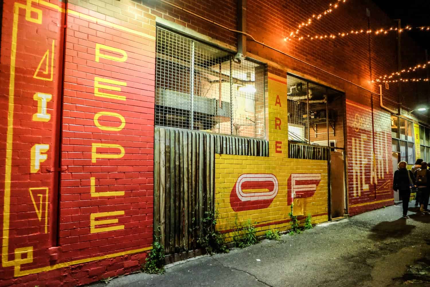 Red and yellow street art saying 'if people are of heart' in Chinatown in Perth, Australia
