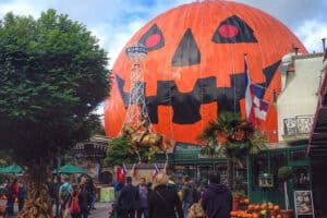 People walking in front of a giant pumpkin tent in Europa Park theme park in Germany.