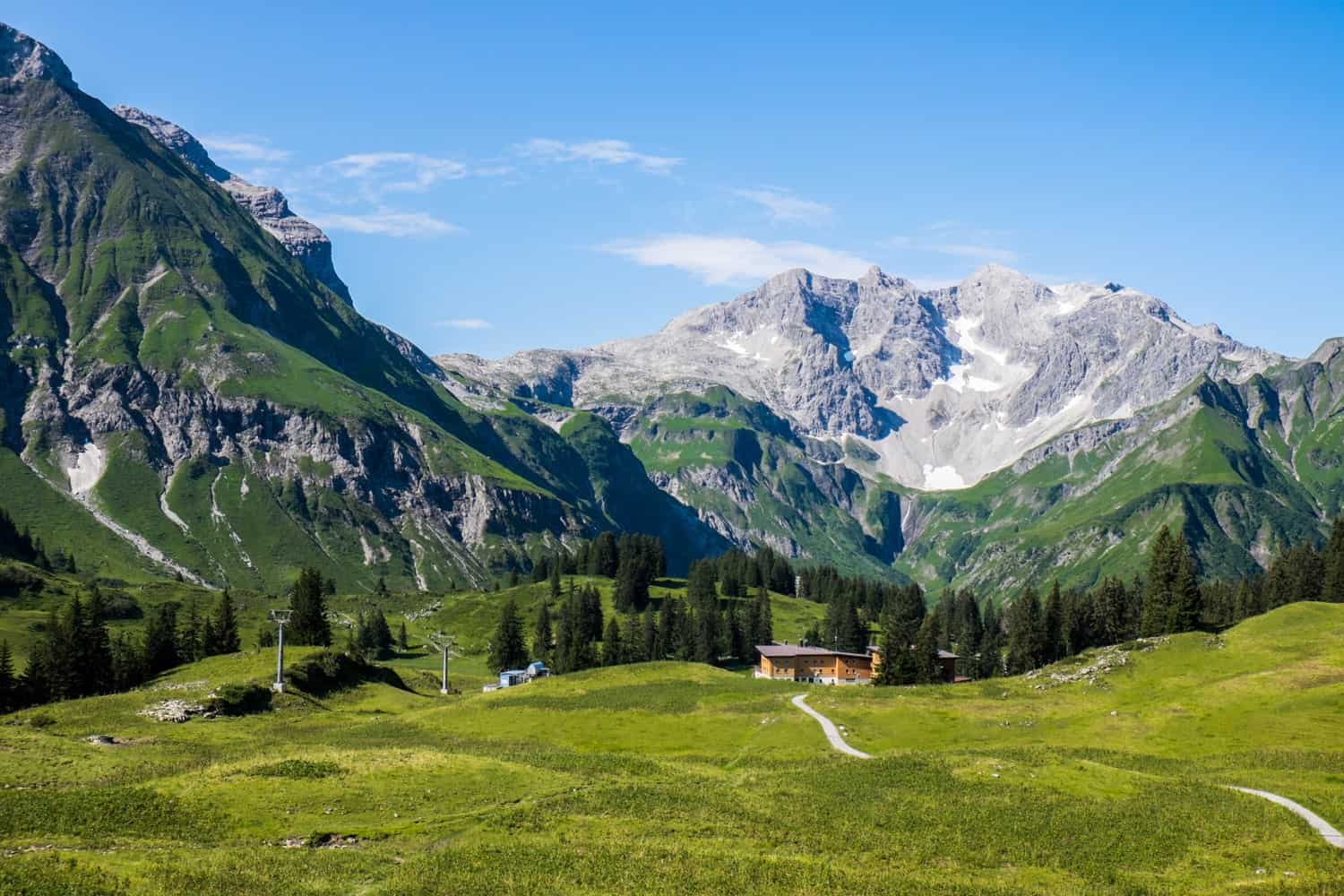 A view of the snow-capped Alps as seen from the summer green alpine pastures in Lech, Austria.