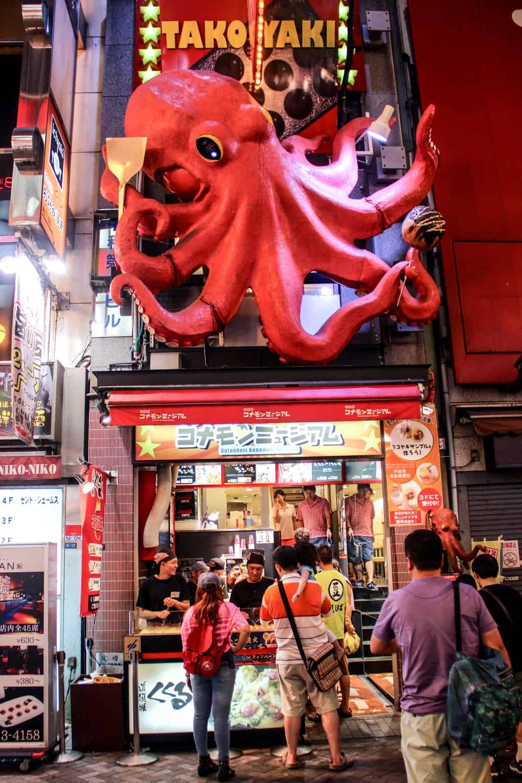 A giant pink octopus with the words Takitaki above a street food stall in Osaka, Japan. 