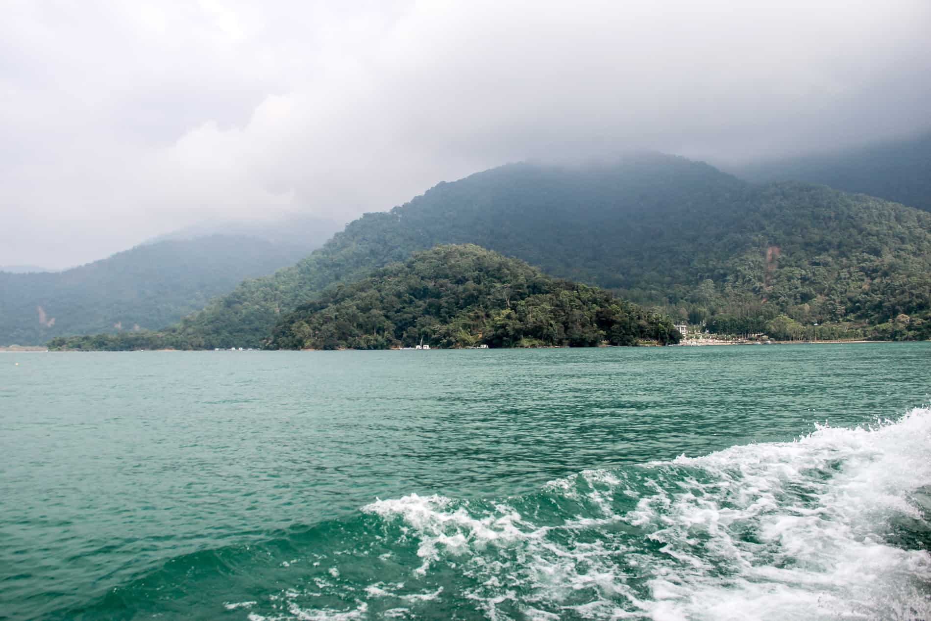 View from the green waters of Sun Mook Lake looking towards the misty covered hills. 