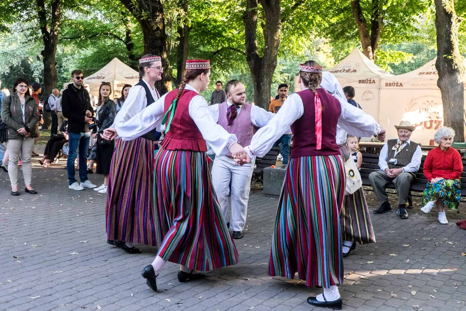Latvian people dancing in the park during a performance at the Song and Dance Celebration in Riga