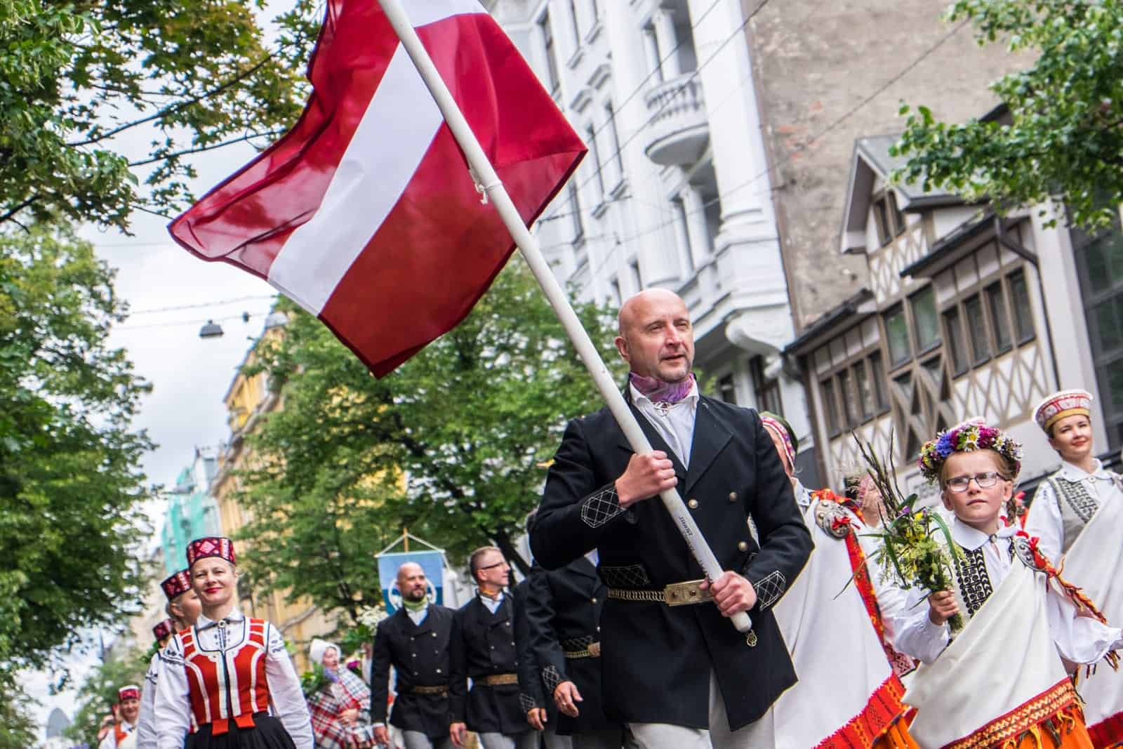 Man waving a Latvia flag at the Song and Dance Celebration in Riga 