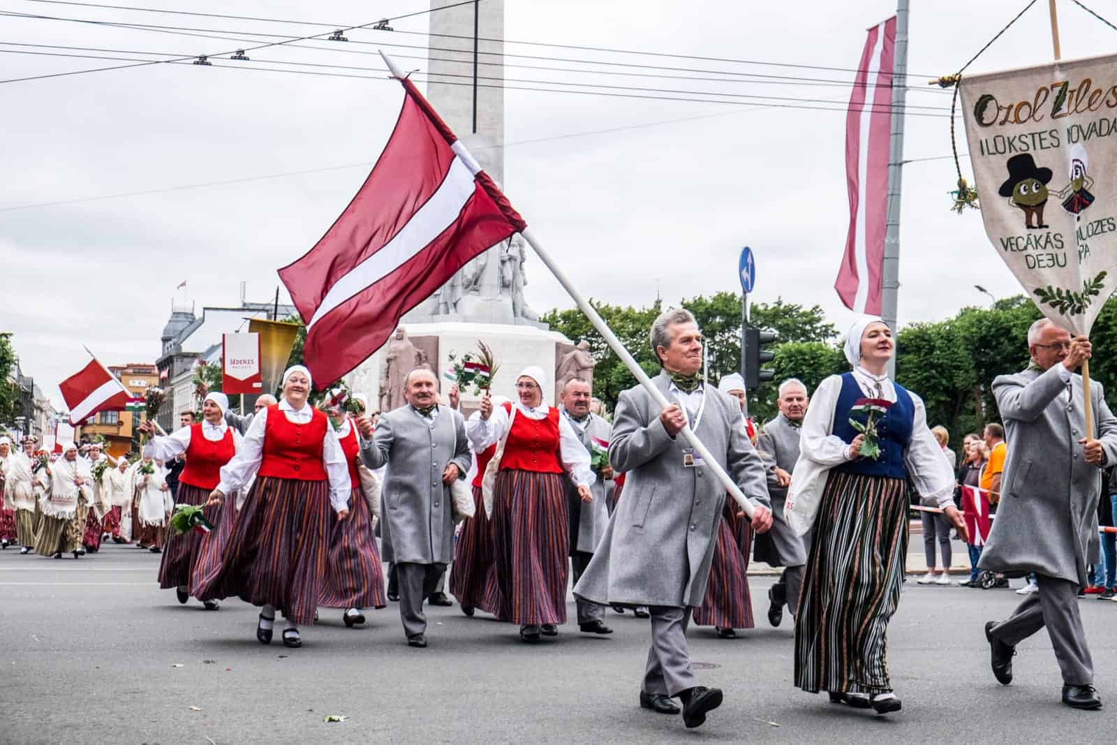 Woman performing in the Latvia Song and Dance Celebration street parade, Freedom Monument in Riga 