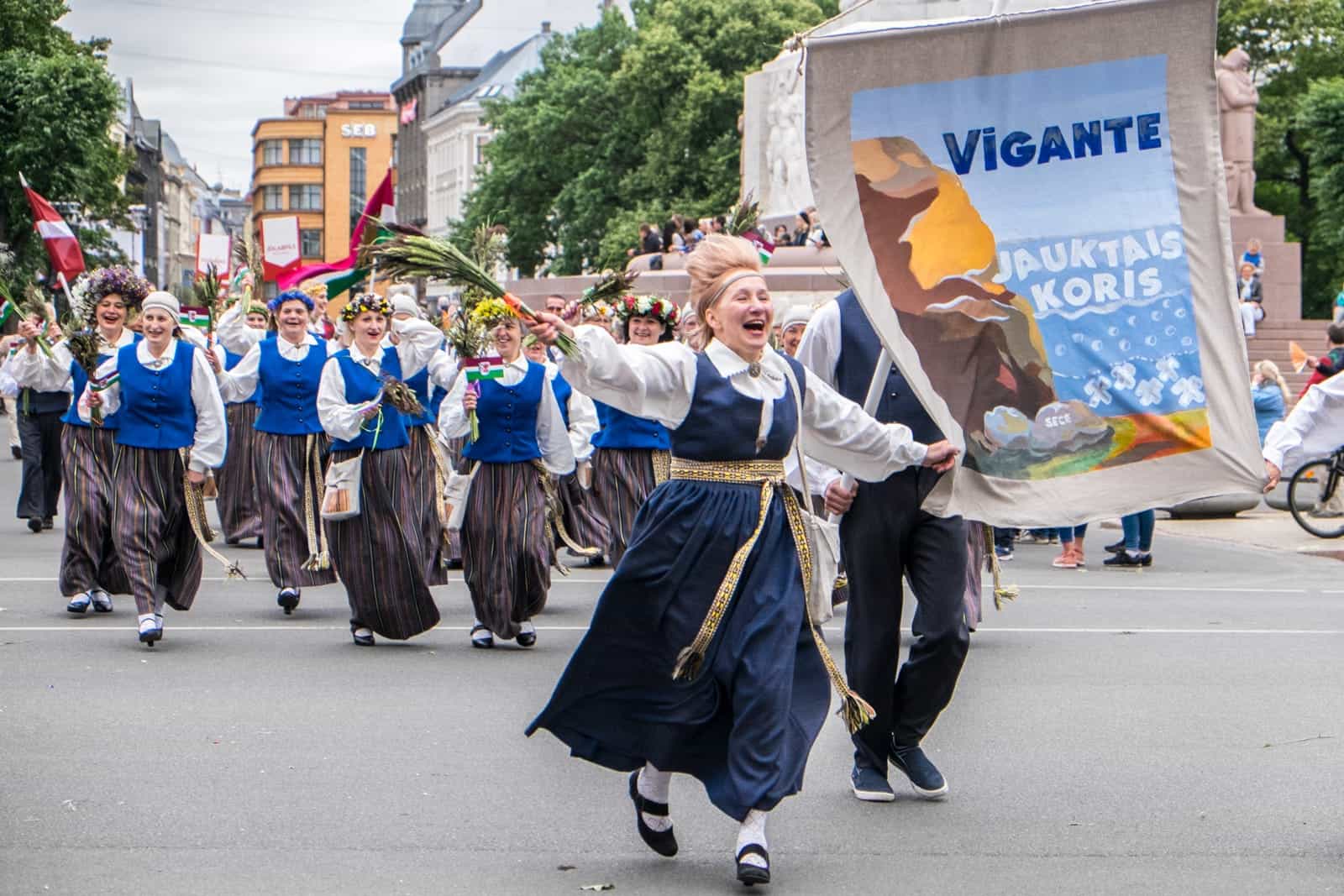 Woman waving flowers at the opening street parade of the Song and Dance Celebration in Latvia