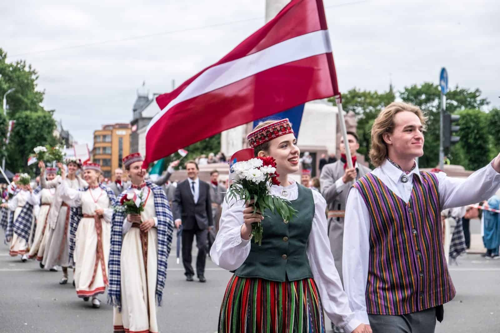 People waving to the crowd at the Song Dance Celebration in Latvia