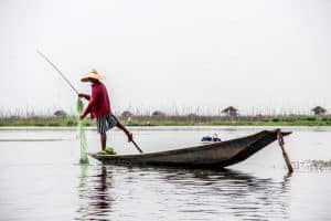 A fisherman on Inle Lake in Myanmar practicing the traditional method of rowing the oar with one leg