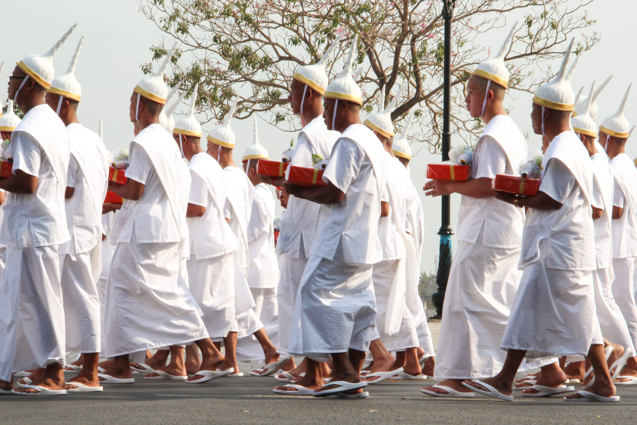 Men in white wearing the pointed Lomphok hat reserved for royalty participating in the royal funeral procession for the late King Norodom Sihanouk of Cambodia.