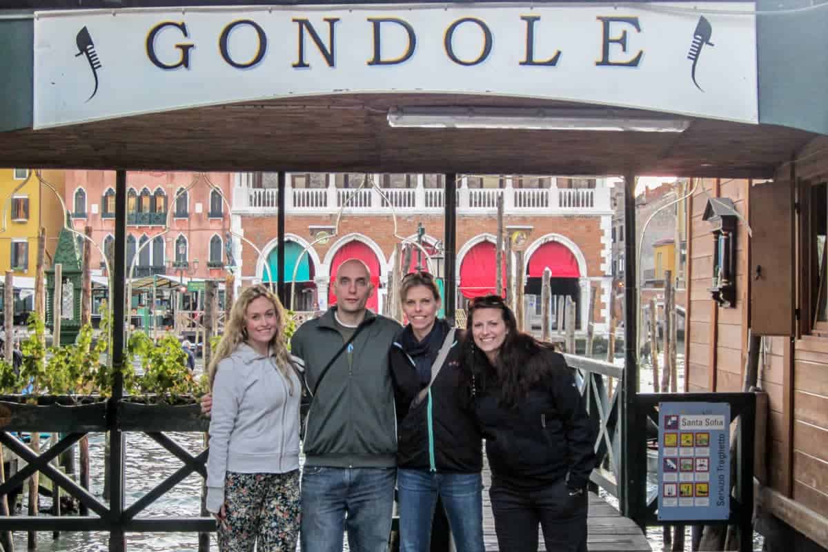 Four tourists at the Gondola station in Venice where the gondola rides end
