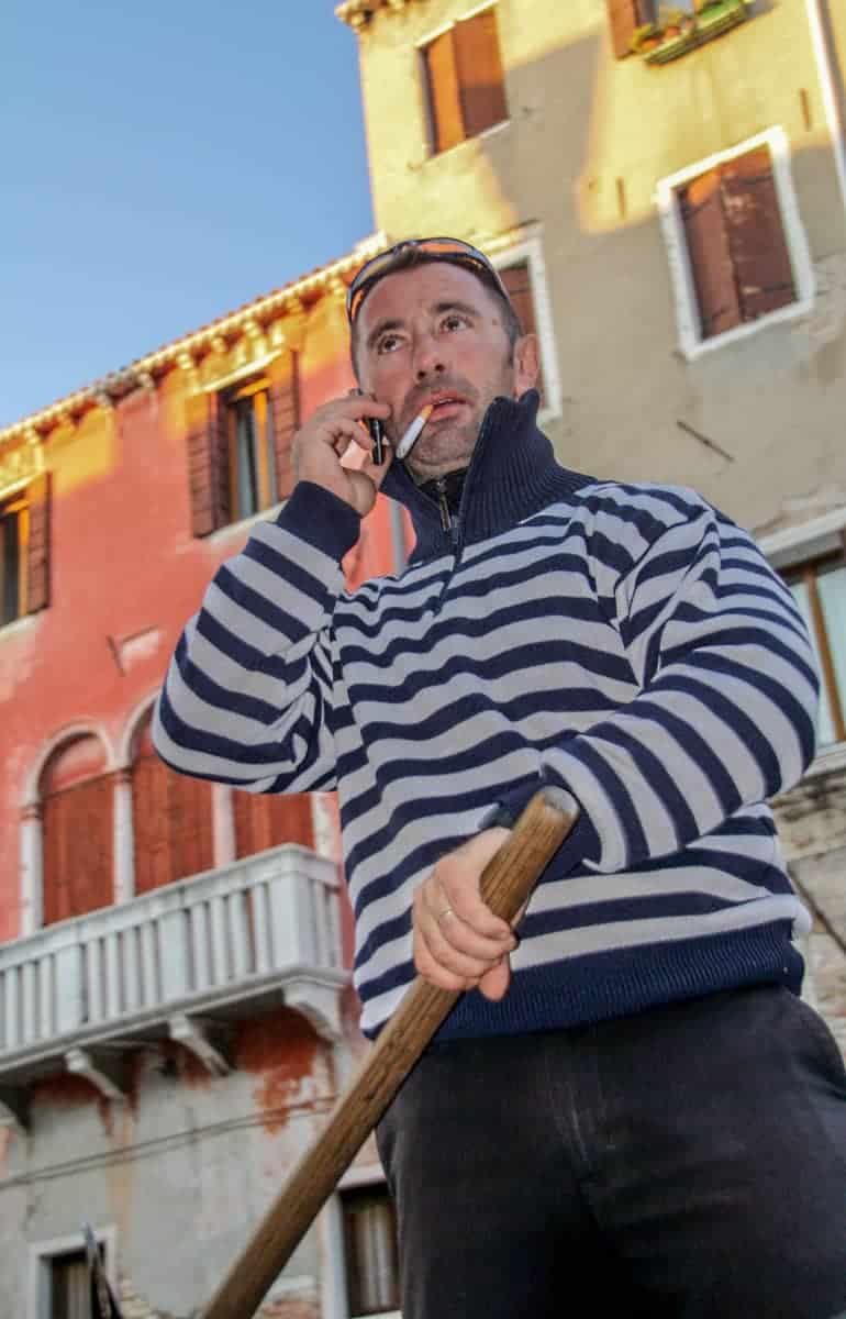 A Gondolier smoking on a cheap gondola ride in Venice