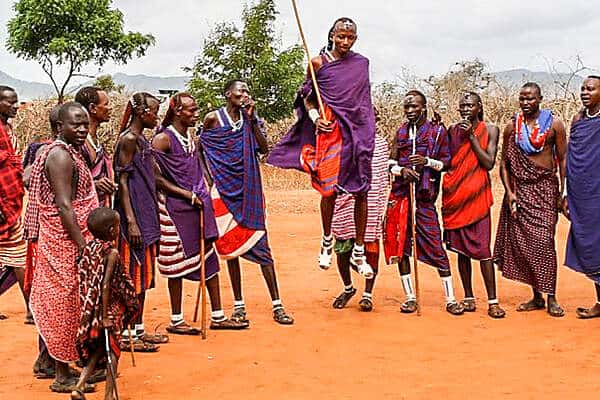 A man from a group of Maasai tribe men in Kenya jumps high in the air as part of a group performance. 