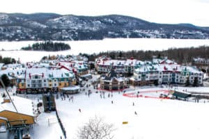Elevated view of the colourful Mont Tremblant Winter Village covered in snow.