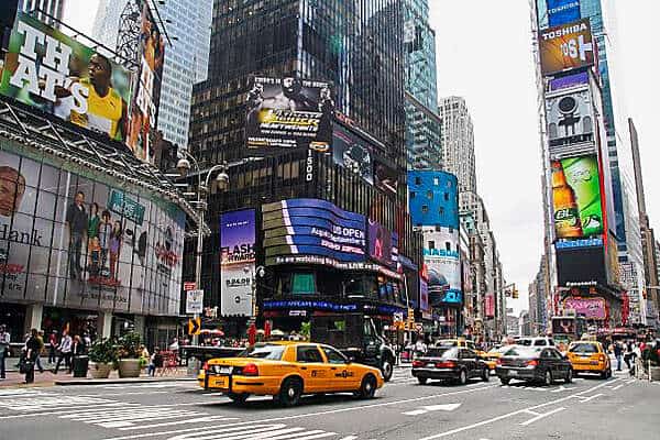 Yellow cabs and people beneath the high rise, advertising clad buildings in Times Square, New York city. 