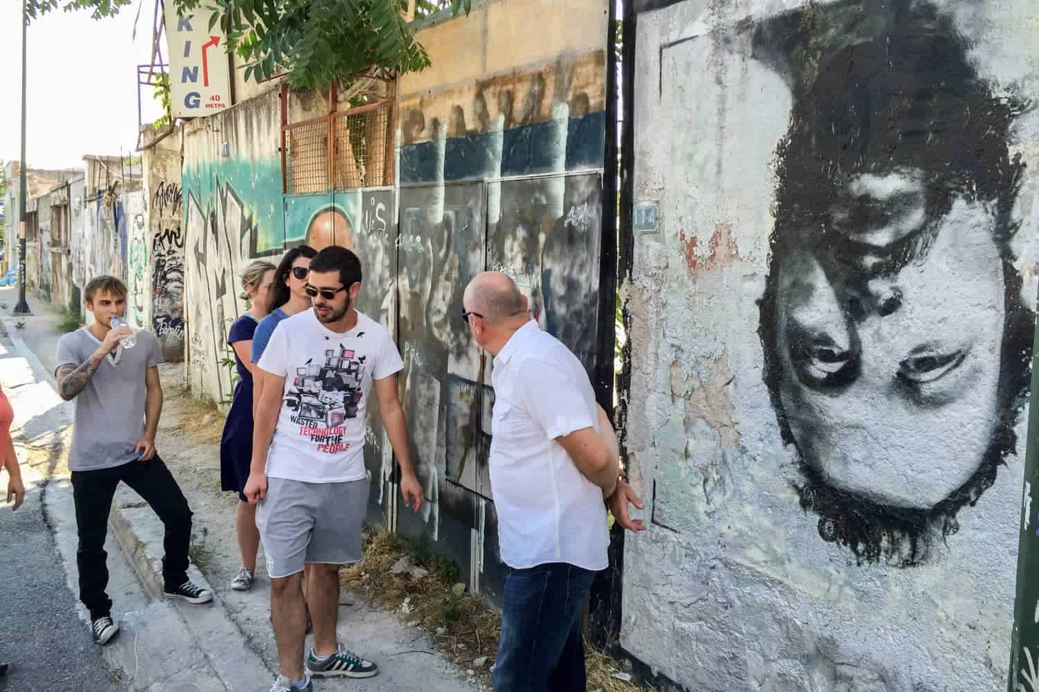 People looking at wall murals during an Athens street art walking tour. 