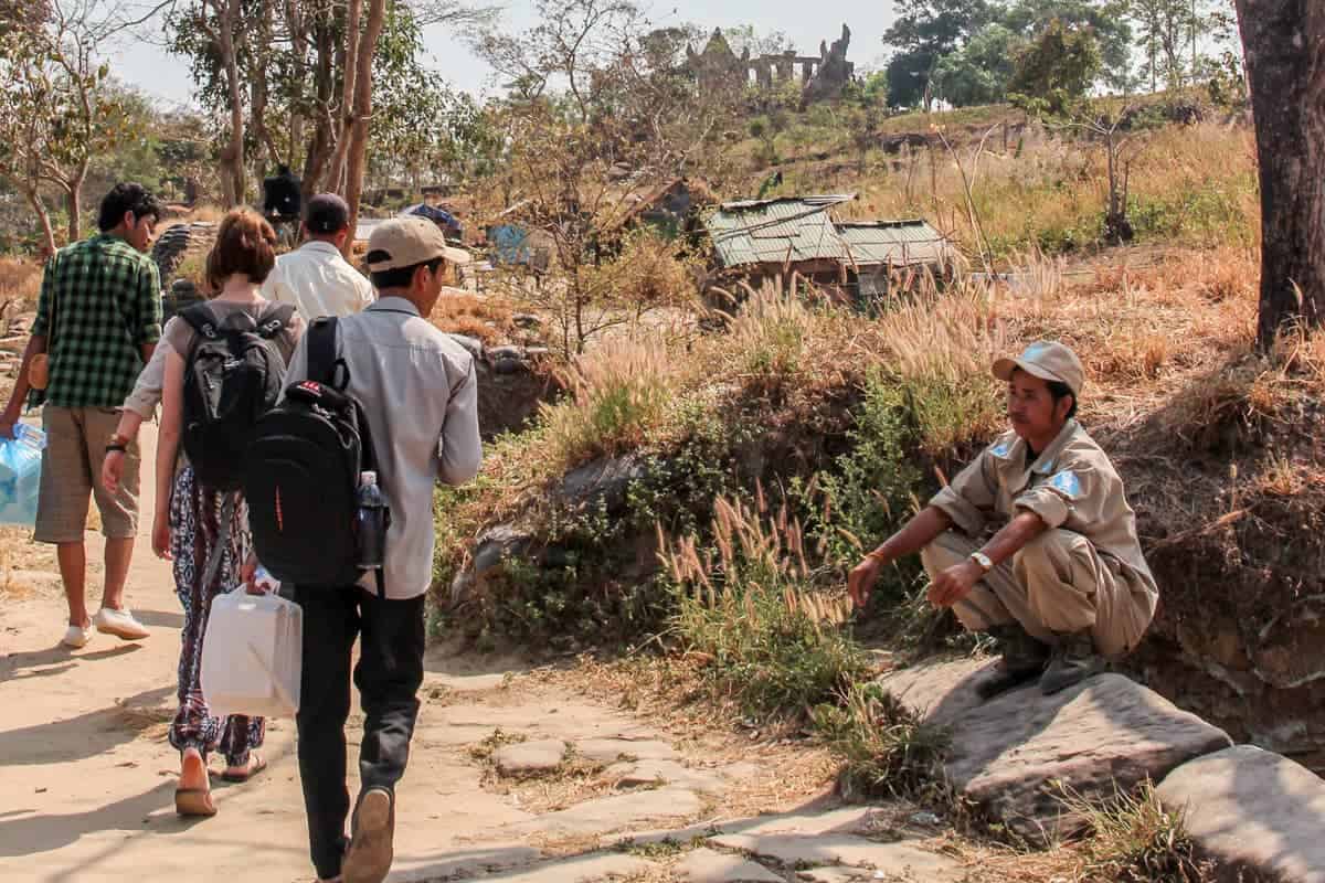 Army mans sits by an army base at Preah Vihear Temple at tourists walk by