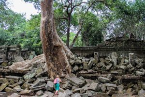 Woman walking over the giant fallen stones of Beng Mealea temple in the jungles of Cambodia