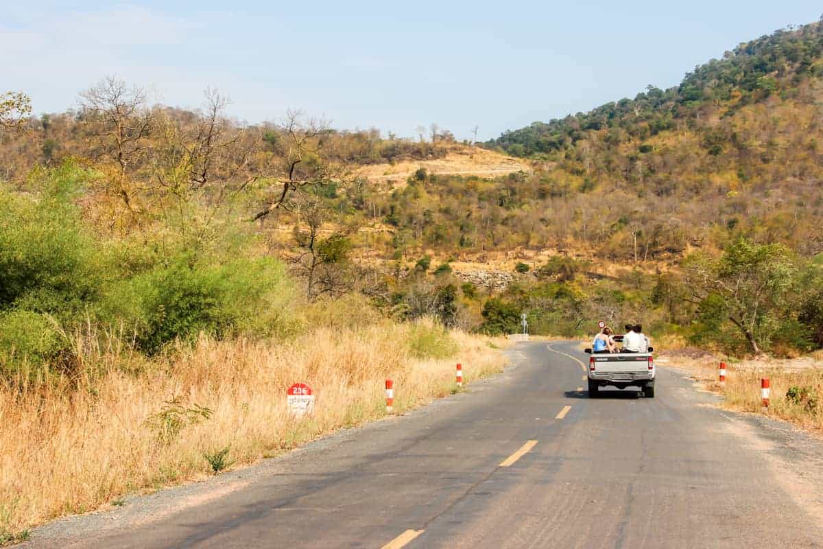 Tourists sit on the back on a jeep to be driven up the high hill leading to Preah Vihear