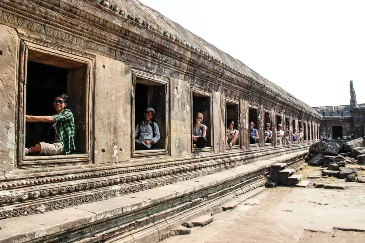 Visitors to Preah Vihear Temple each sit in one of the windows looking out in a long line