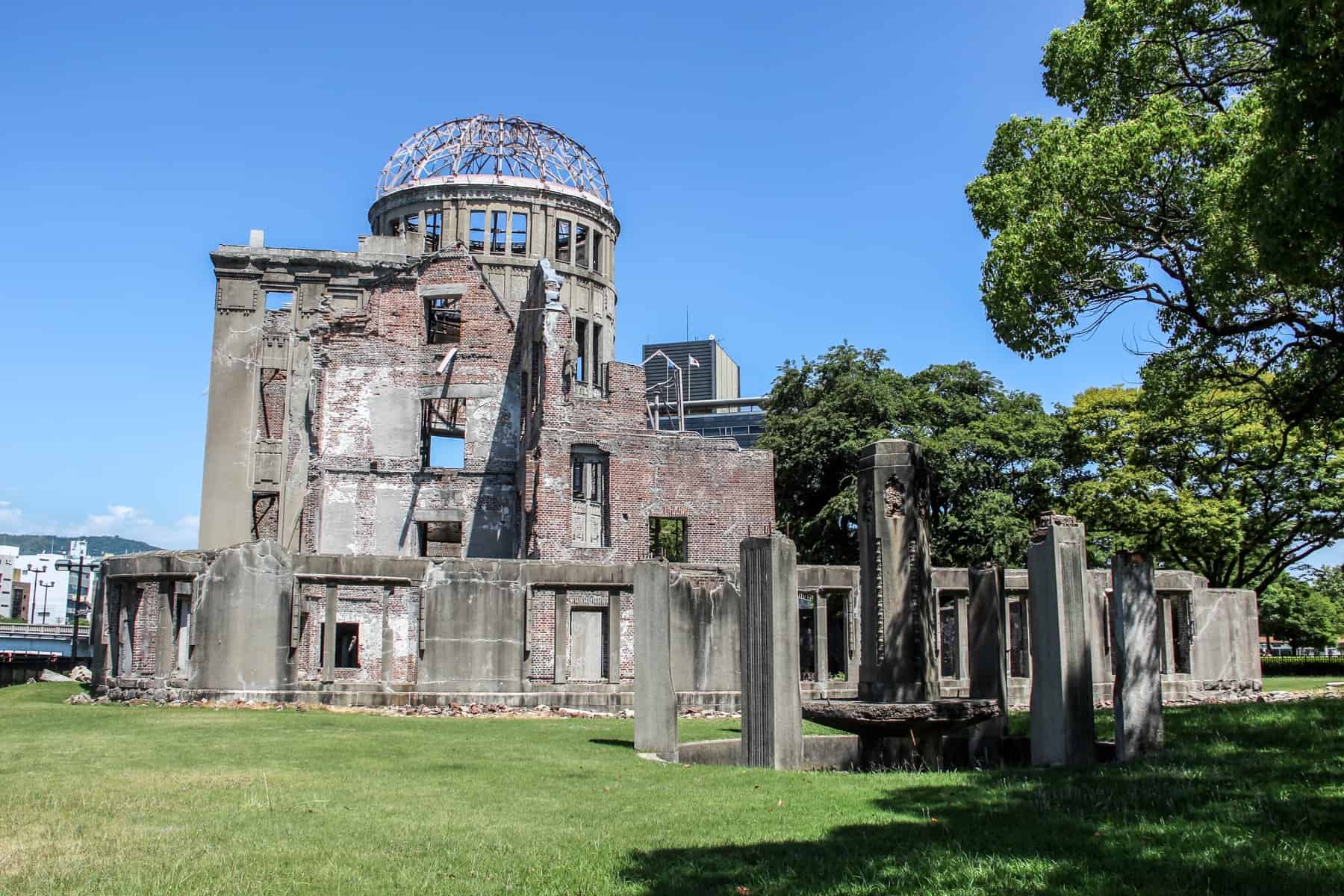 The building shell ruins of the Atomic Bomb Dome in Hiroshima set in the green Peace Park Memorial grounds. 