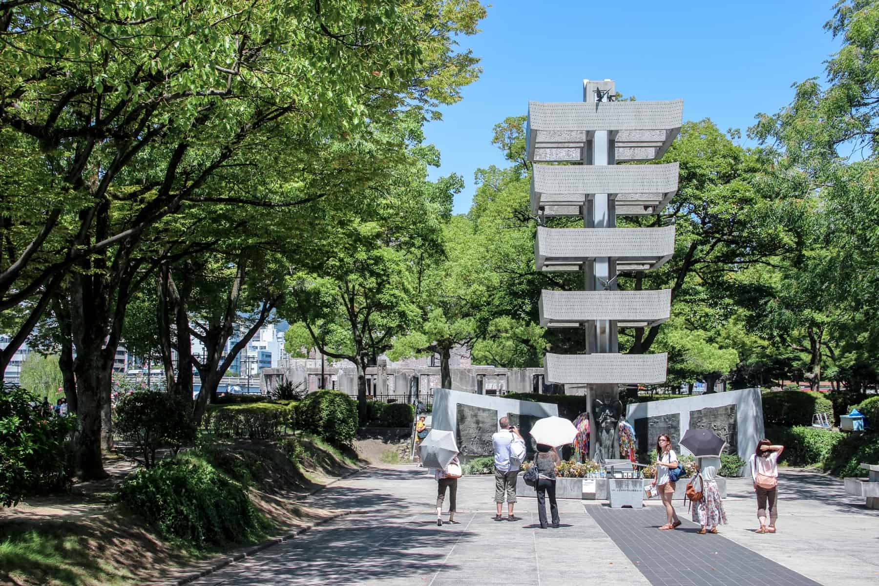 A five tier pagoda sculpture in the tree-filled Hiroshima Peace Park Memorial site.