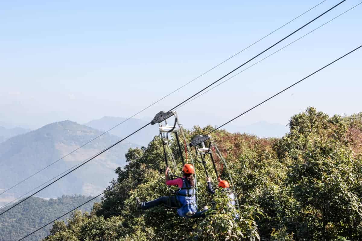Two people start a decent on a double line wire zipline in Nepal
