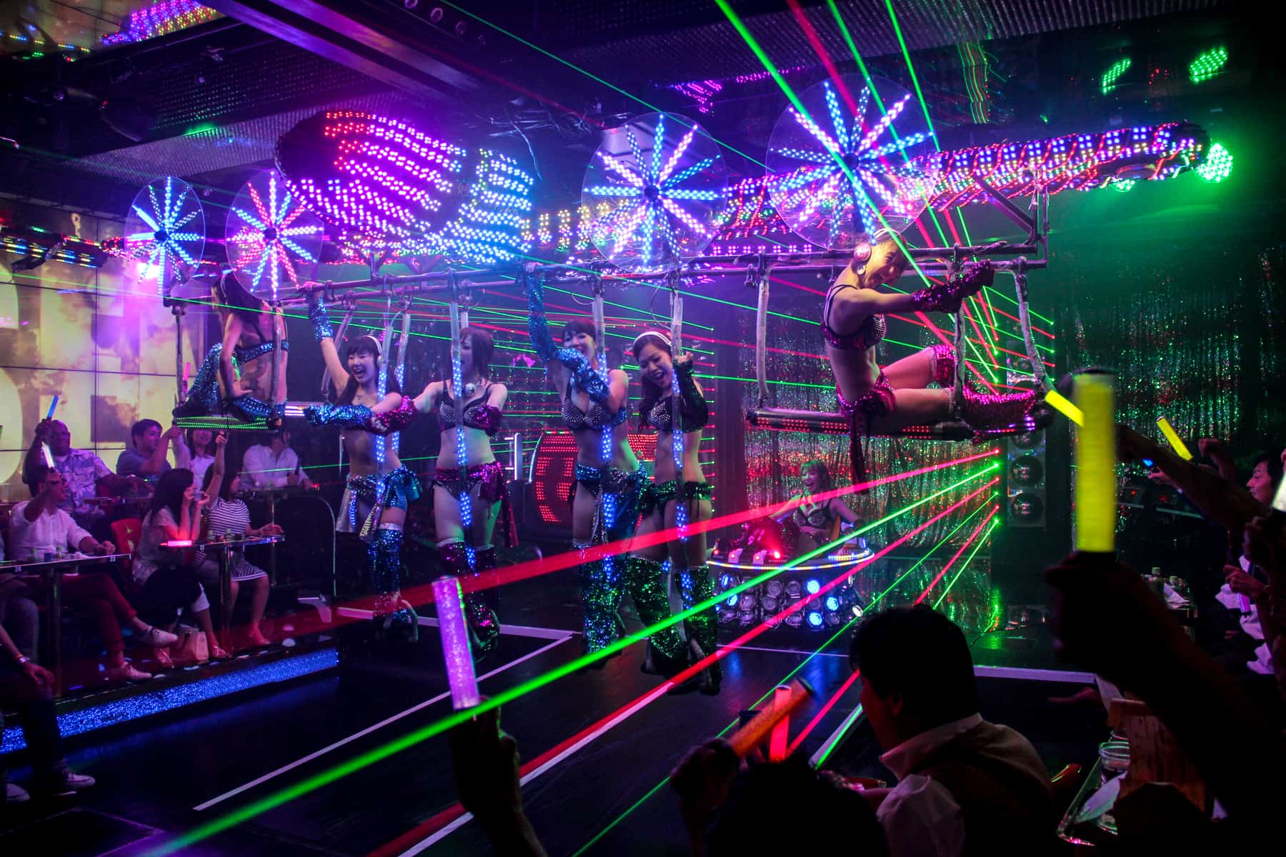 Women performing with neon lights and laser beans at the Robot Restaurant in Tokyo. 