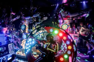 A robot in a circular car rides past three tall feminine robots at the Robot Restaurant show in Tokyo.